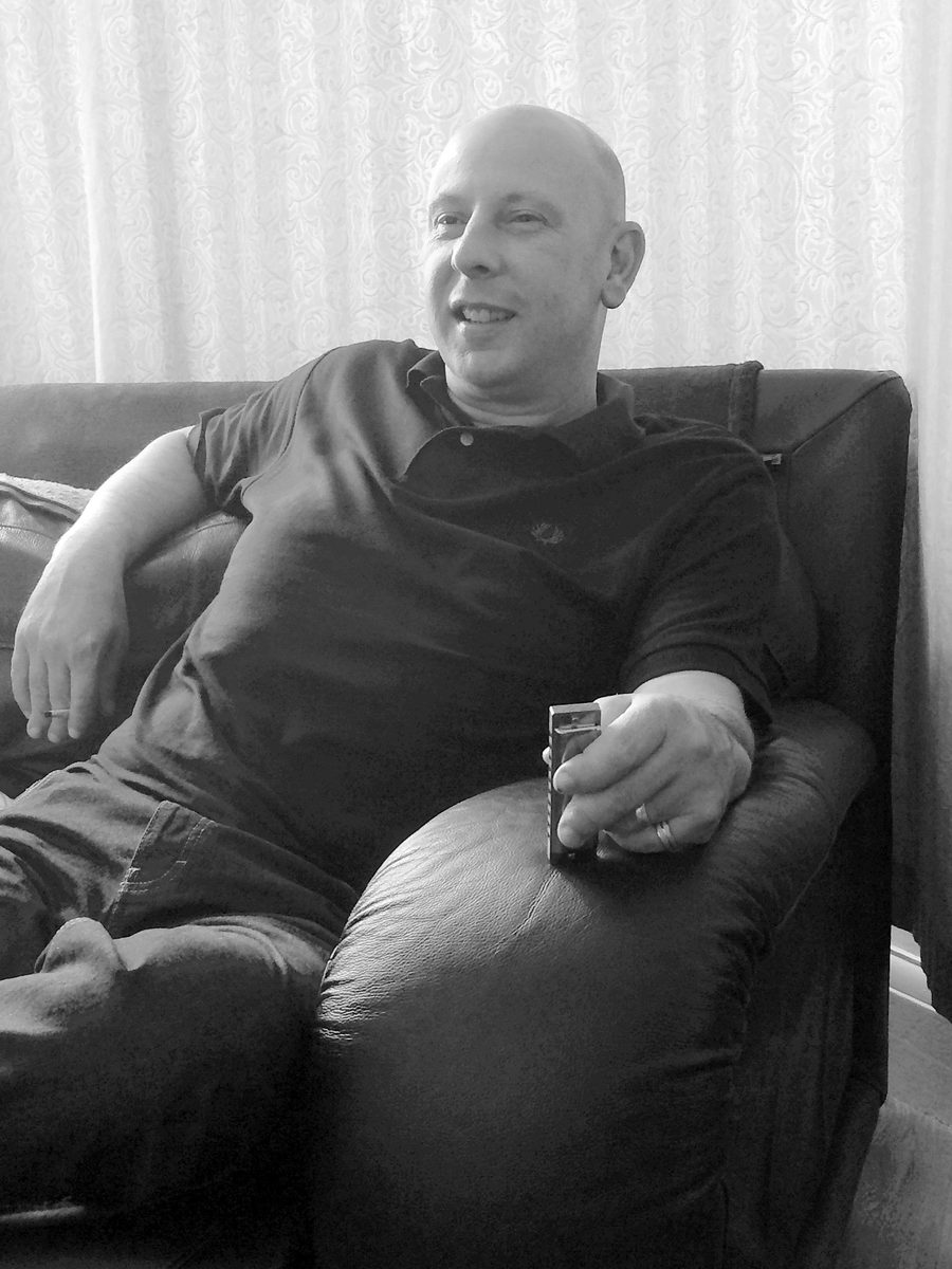 David Yabsley relaxing on a sofa, holding a harmonica